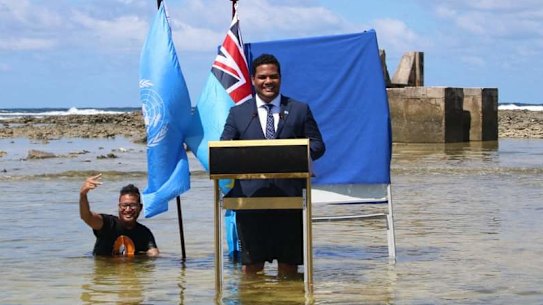 Tuvalu Foreign Affairs Minister Simon Kofe addressing COP26 standing in the rising seas threatening his island nation.