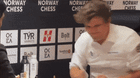 Top chess player Magnus Carlsen reacts after losing to world champion Gukesh Dommaraju in a classical match for the first time. GIF