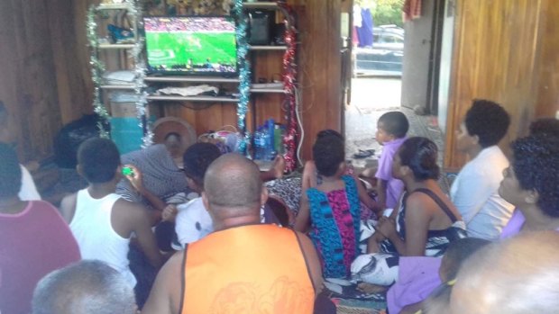 Packed house: Family and friends in Fiji gather to watch Maiko Sivo's NRL debut.