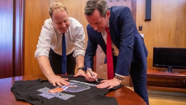 Mark McGowan signing the t-shirt and David Michael MLA in the Premier's Parliament House offices.