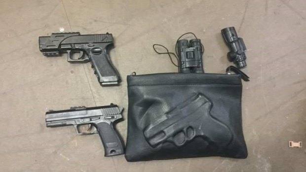 Three handguns and binoculars found in the storage shed, according to police.