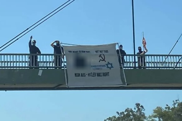 Police allege the three men were involved in displaying a Nazi banner over the Pacific Highway last year.