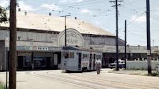 A tram of yore rides past the old picture theatre that's now an antiques shop.