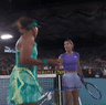 Naomi Osaka and Sorana Cirstea exchange words at the net.