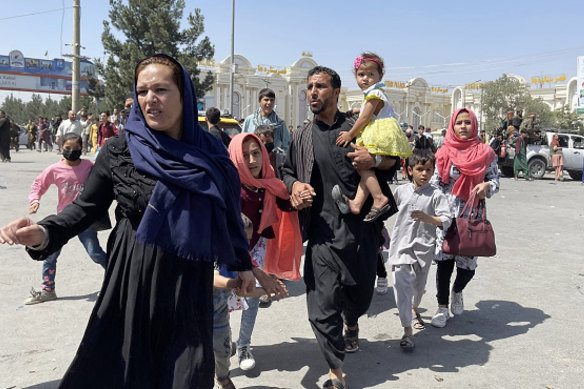A family rushes to Kabul’s airport after the Taliban takeover. 