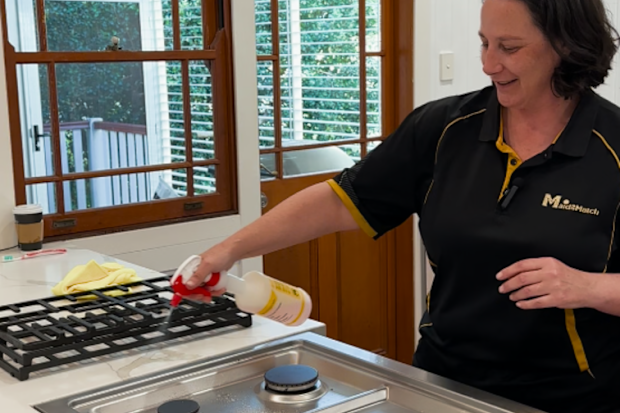 Professional cleaner Cherie Polwarth from Maid2Match degreasing a stove top.