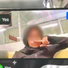 A screenshot of a student holding their finger to their nose, appearing to imitate a Hitler moustache.