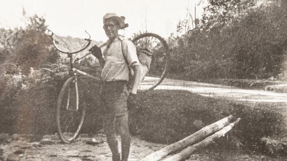 Alan McArthur carries his bike across a creek during the ride.