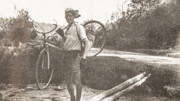 Alan McArthur carries his bike across a creek during the ride.