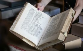 A librarian handles a rare Russian book in Lithuania.