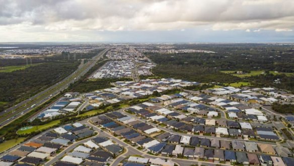 A sea of black roofs can be seen from the sky extending along the freeway.