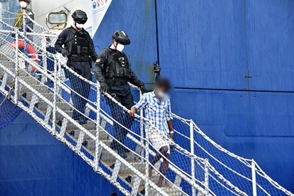 One of the Sri Lankan men is led off the Ocean Shield in Colombo on Friday.