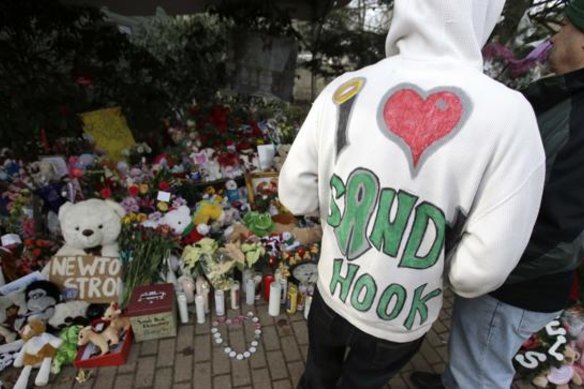 A Sandy Hook resident wears a handmade sweatshirt in support of his town while looking at a memorial to the Newtown shooting victims in the Sandy Hook village of Newtown, Connecticut.