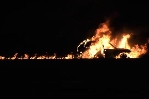 A stolen black Porsche Cayenne burns after it was used in the Love Machine nightclub shooting.