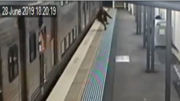 Camera footage shows a man jump from a moving train onto a station platform in June.