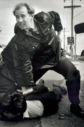 Constable Glenn Pullin arrests a man outside the rollerskating rink in Noble Park in 1992.