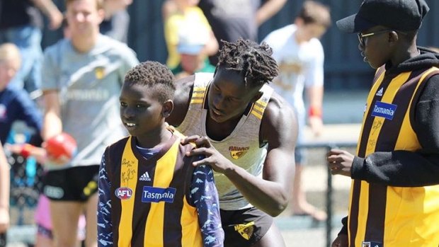 Hawthorn rookie Changkuoth Jiath, signing jumpers at a family day, will make his AFL debut on Friday. 