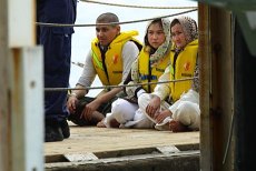 Asylum seekers offloaded from the HMAS Melville at Christmas Island's Flying Fish Cove on Easter Sunday, 2013.