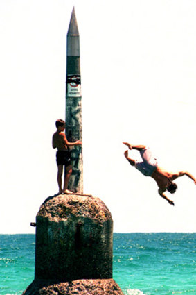 Swimmers jump off Cottesloe's famous beach pylon. Photo: AFR