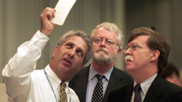 Palm Beach Canvassing Board Chair Judge Charles Burton (left) displays a questionable ballot to Democratic attorney Gerry McDonough as then-Republican attorney John Bolton looks on in November 18, 2000. 