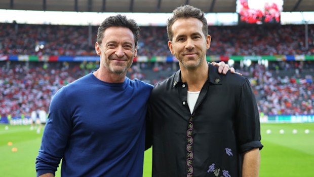 Hugh Jackman and Ryan Reynolds enjoy the pre match atmosphere.