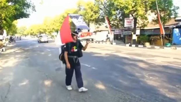 Medi Bastoni walks about 30km a day with a buddy who helps keep traffic away. His backpack has a mounted rear (or front) vision mirror.