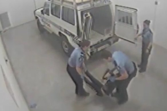 Footage of Ms Dhu being loaded into the back of a police van.