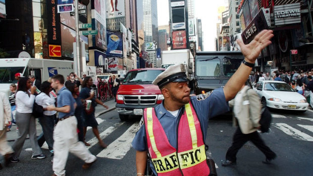 A New York City police officer directs traffic through New York's Times Square.