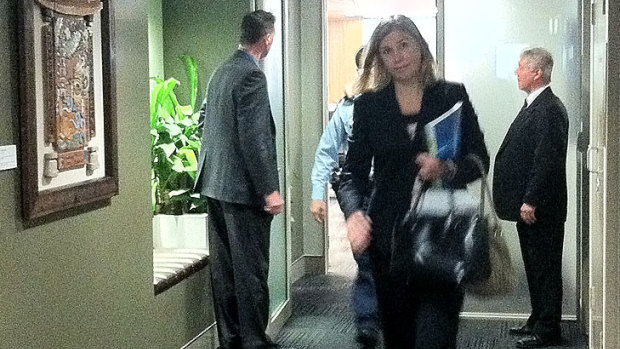 Nicole Johnston leaves council chambers with a police escort in 2012.