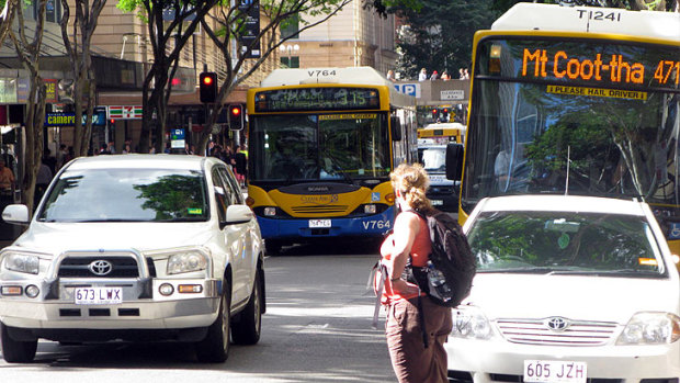 Buses, cars and pedestrians jostle for position on Adelaide Street in Brisbane's CBD.