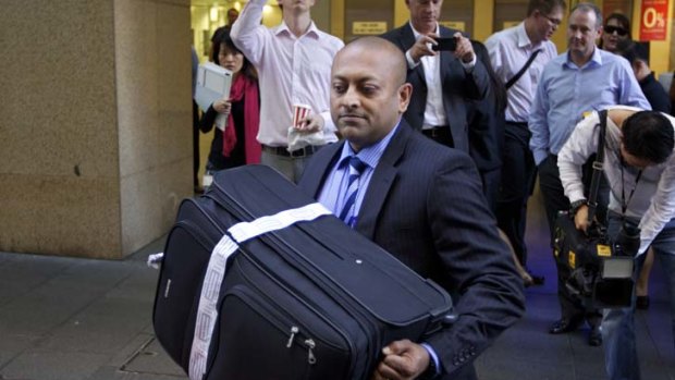 Detective Sergeant Ron Prasad with the suitcase seized from Michael Williamson during a 2012 raid on the HSU's Sydney offices.