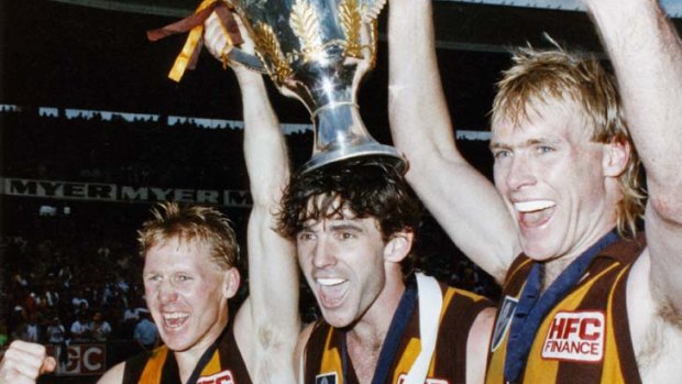 Hawks Andy Collins, Dean Anderson and Peter Curran celebrate with the 1989 premiership cup.