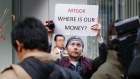 Kolin Burges holds up a placard in protest in 2014 after more than 700,000 bitcoins went missing.