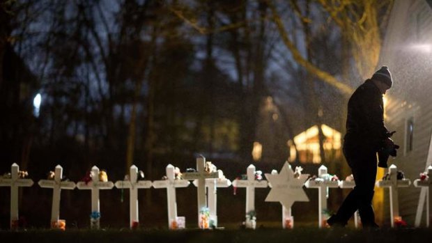 Frank Kulick, walks past a display of wooden crosses, and a Jewish Star of David, representing the victims of the Sandy Hook Elementary School shooting.