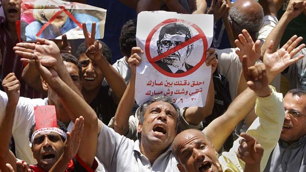Egyptian protesters shout anti-Muslim Brotherhood slogans as they hold a poster depicting then-president Mohammed Morsi during a protest in Tahrir Square, Cairo, the focal point of the uprising in June 2013. 
