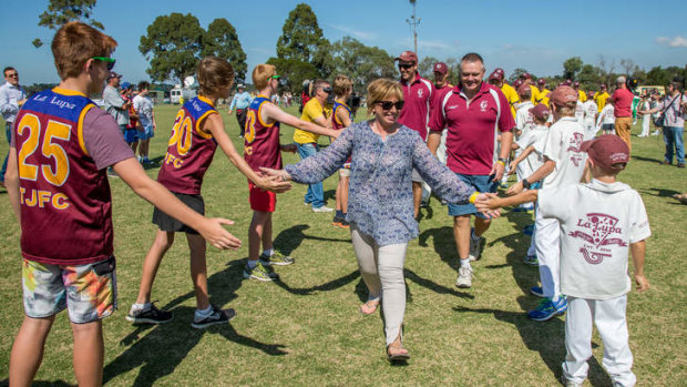 Rosie Batty leads the teams out on Tyabb Oval through a guard of honour at a football match in his honor.