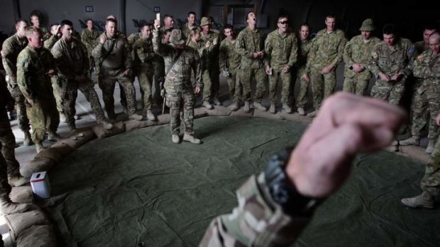 Soldiers play two-up after the ANZAC day dawn service at Multinational Base Tarin Kot, in Afghanistan, on 25 April 2013.