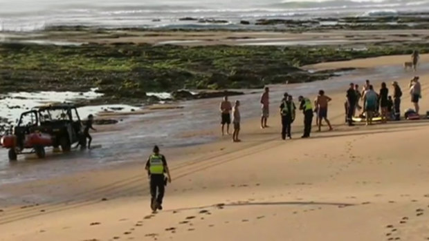 Volunteers bring the two men ashore at Woolamia beach.