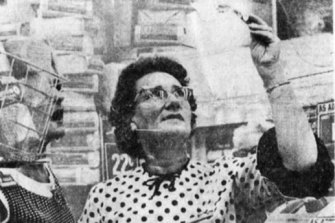 A shop assistant in Bourke Street holds up a $10 note to the light to check its authenticity.
