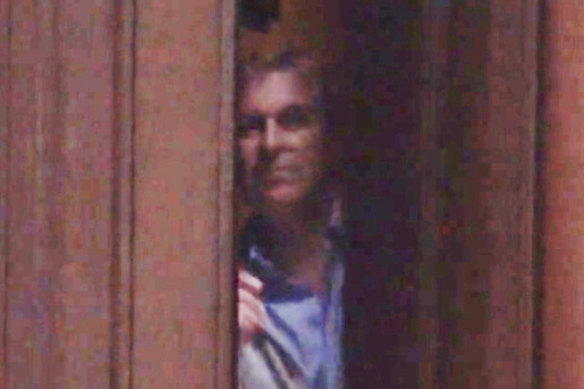 Prince Andrew peering out from behind the door of Epstein’s Manhattan mansion in 2010.