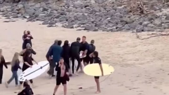 Boy being taken on a surfboard out of Cabarita beach after being attacked by a shark. 