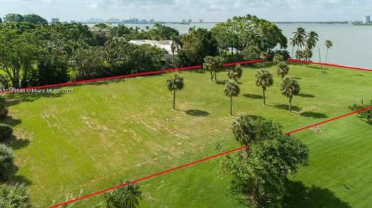 A bare patch of land next door to the world’s second-richest man has sold after six months on the market. 