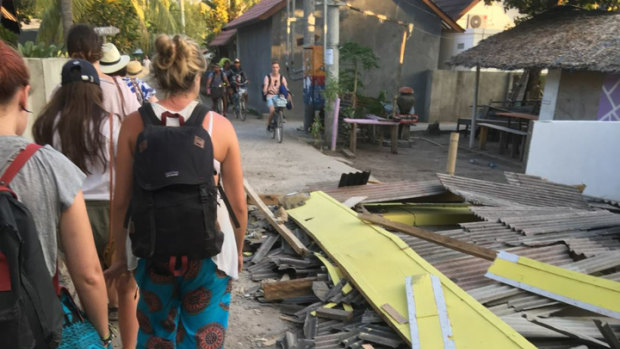 Mills and her friends walk past collapsed buildings on Gili Air.