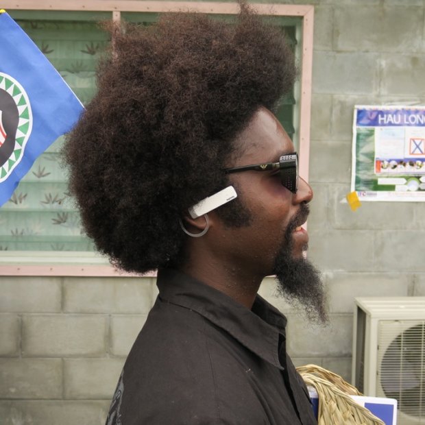 A man plants a Bougainville flag in his hair as he queues up to vote on the opening day of the territory's independence referendum.