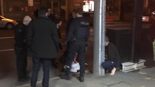 Witness photo shows restrained victim lying on the ground in front of police at Fitzroy on May 11, 2019.
