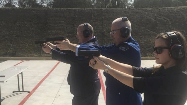 Mr Elliott, left, firing a pistol.