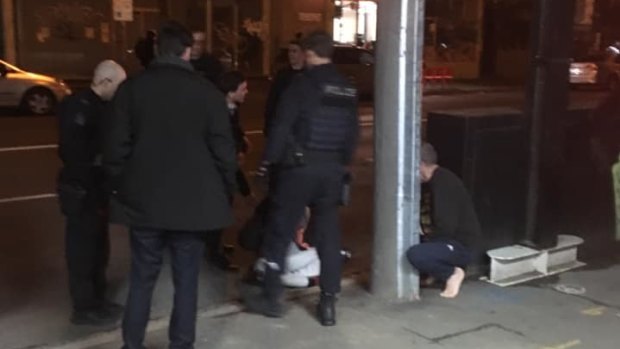 Witness photo shows restrained victim lying on the ground in front of police at Fitzroy on May 11, 2019.