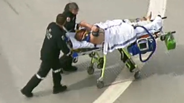 Tony Mokbel shakes the hand of a paramedic as he arrives at Royal Melbourne Hospital after being stabbed on February 11.