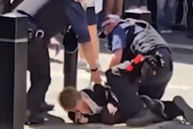 A crowd of people watched on as the woman who allegedly stabbed multiple people was detained by police.