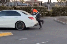 The owner of a car workshop has clung to the boot of a moving Mercedes-Benz during a heated confrontation in a shopping centre car park in Melbourne’s south-east.